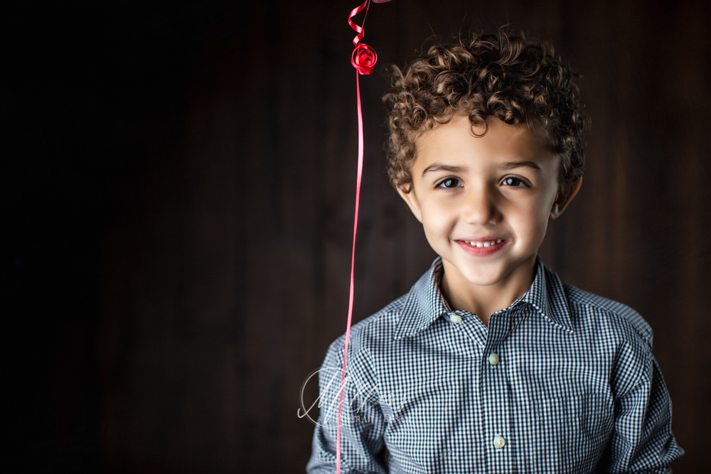 Birthday boy portraits with red balloon and teddy bear